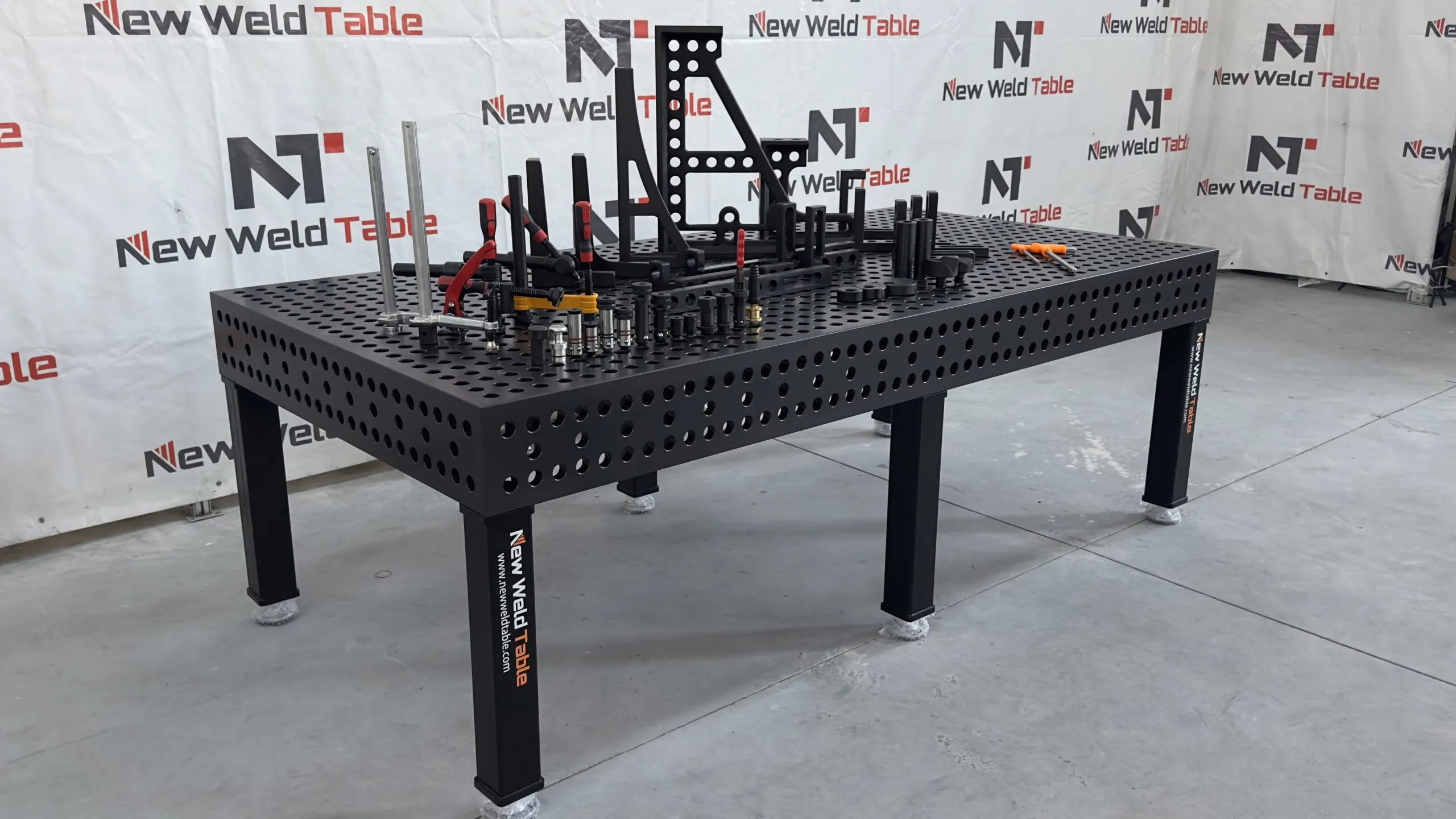 Modular welding table with positioning fixtures and adjacent tool storage