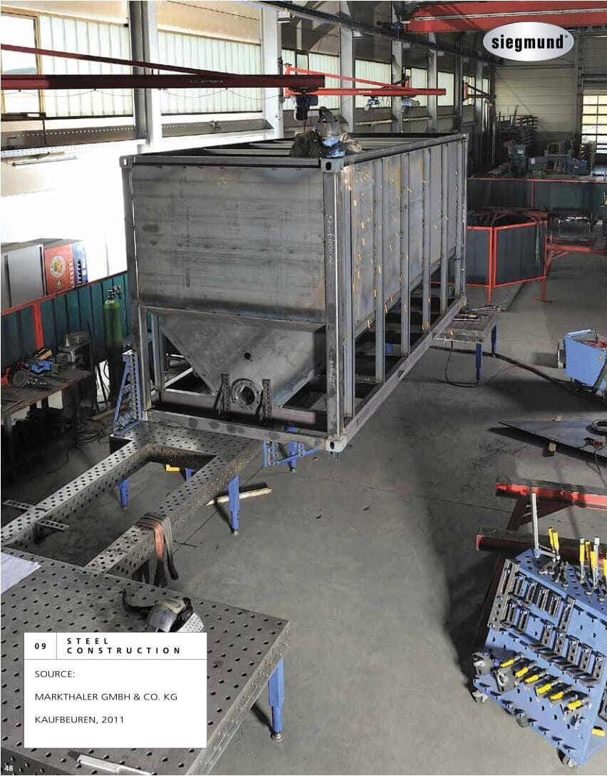 Large steel assembly positioned on modular welding tables and separate supports